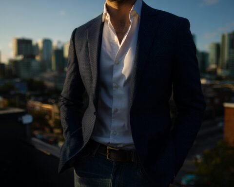 A confident man on a rooftop during golden hour showcasing stylemaxxing men's fashion with tailored clothing that enhances height and frame.